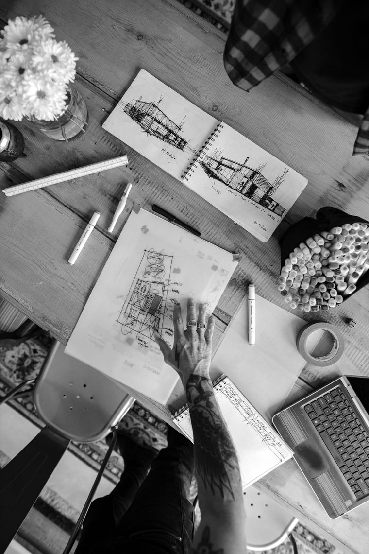 A studio desk with architectural sketches and markers