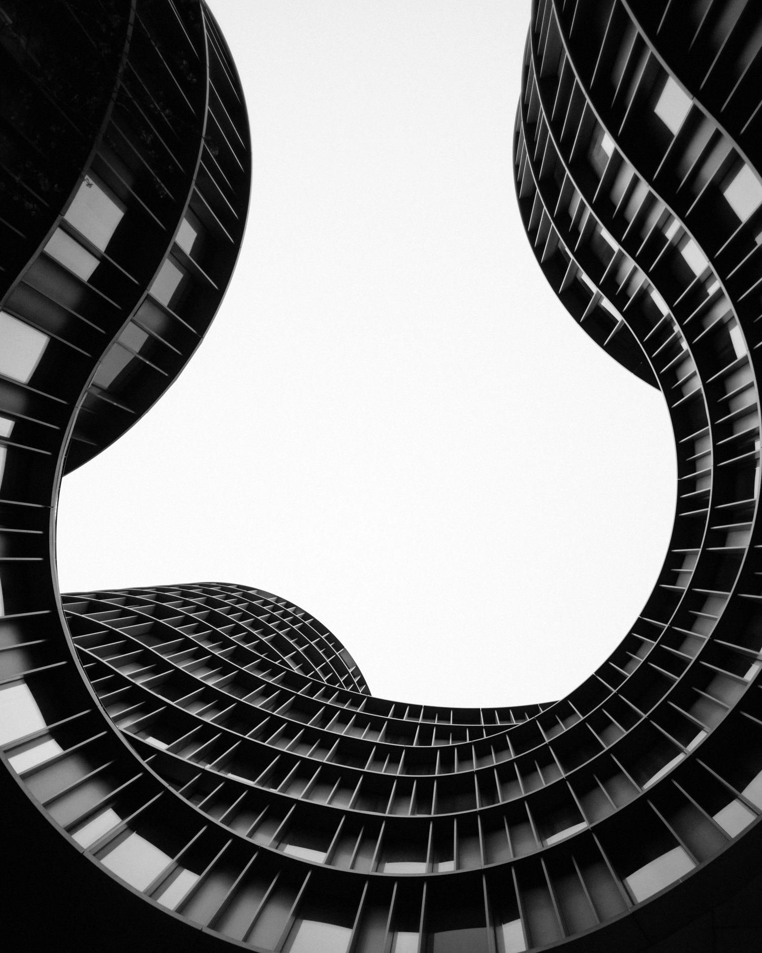 Looking up through curved architecture toward an aperture of sky